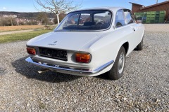  Schrägansicht Heckansicht Alfa Romeo GTV 1750 GT mit landschaftlichem Hintergrund | Alfa Romeo GTV 1750 GT – Schrägansicht Heckansicht