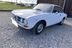 Front- und Seitenansicht eines Alfa Romeo GTV 1750 GT auf einem Kiesplatz | Alfa Romeo GTV 1750 GT – Front- und Seitenansicht