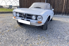 Schrägfrontansicht eines Alfa Romeo GTV 1750 GT vor rustikaler Holzscheune | Alfa Romeo GTV 1750 GT – Schrägfrontansicht