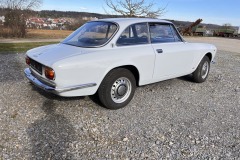 eitliche Heckansicht eines Alfa Romeo GTV 1750 GT auf einem Kiesplatz | Alfa Romeo GTV 1750 GT – Seitliche Heckansicht