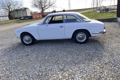 Seitenansicht eines weißen Alfa Romeo GTV 1750 GT in einer ländlichen Umgebung | Alfa Romeo GTV 1750 GT – Seitenansicht