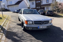 Frontansicht eines Mercedes-Benz 500 SEC W126 Baujahr 1982 auf einer sonnigen Landstraße | Mercedes-Benz 500 SEC W126 – Frontansicht auf Landstraße