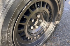 Detailansicht einer matt-schwarzen Alufelge mit Reifenprofil | Alufelge des Mercedes-Benz 500 SEC Baujahr 1982