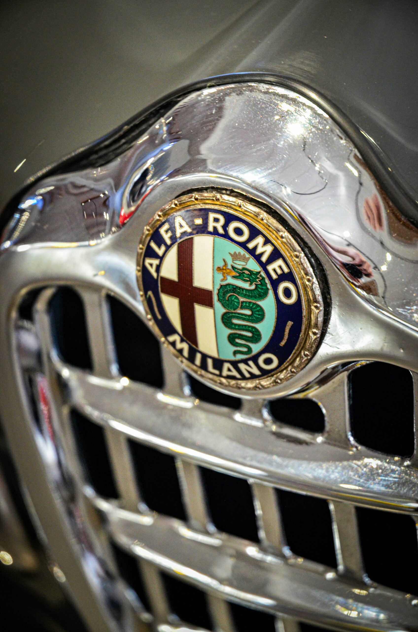 Nahaufnahme des Alfa Romeo-Logos auf einem klassischen Kühlergrill.