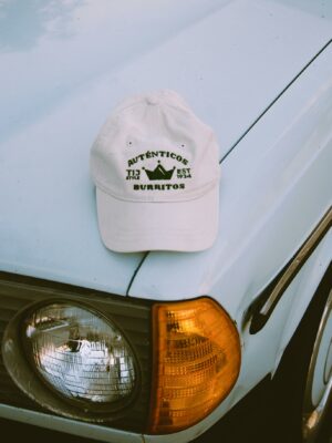 Vintage white car with a branded cap on its hood, featuring unique design elements.