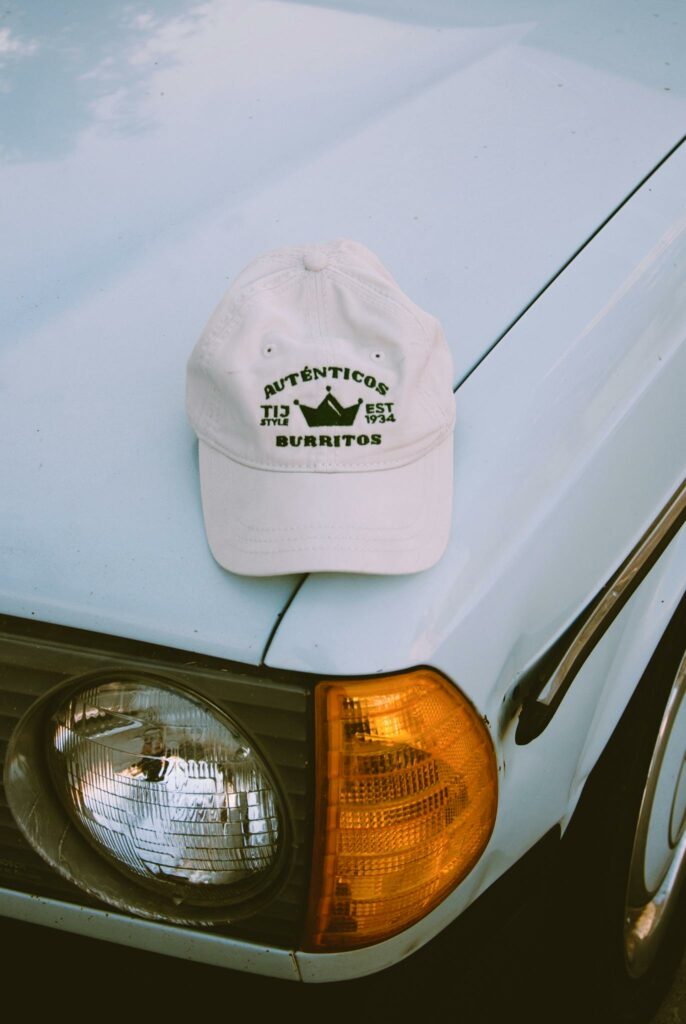 Vintage white car with a branded cap on its hood, featuring unique design elements.